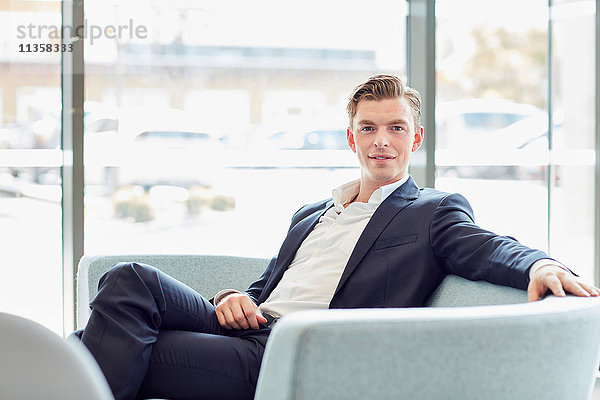 Porträt eines jungen männlichen Geschäftsmannes auf Bürosofa