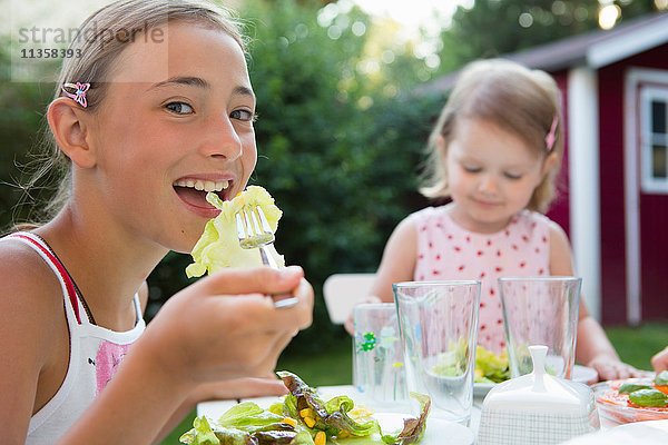 Porträt eines Mädchens beim Salatessen im Garten  Bayern  Deutschland