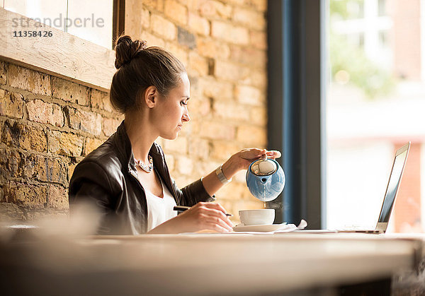 Junge Geschäftsfrau beim Tee trinken im Café