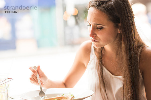 Junge Frau beim Mittagessen im Restaurant