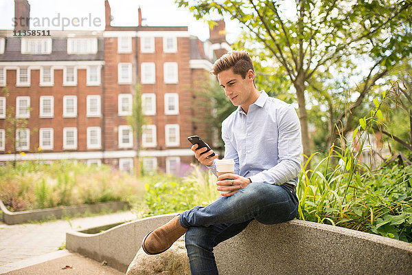 Geschäftsmann beim Lesen von Smartphone-Texten in der Stadt  London  UK