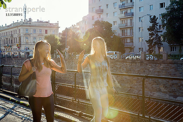 Zwei erwachsene Freundinnen geben sich gegenseitig ein High Fiving in der Stadt  Wien  Österreich