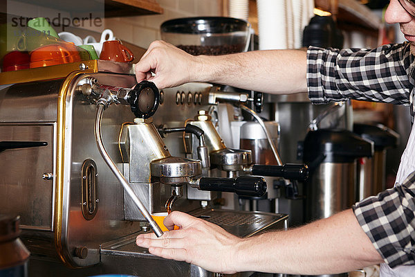 Männlicher Arbeiter in einer Bäckerei  Kaffeemaschine benutzend  Nahaufnahme