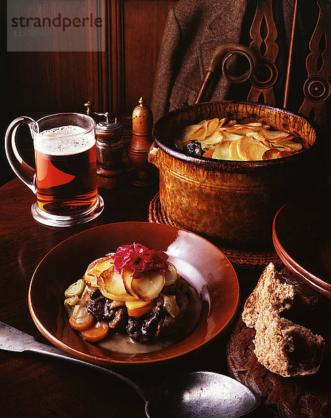 Hirschragout mit Rotkohl  Kartoffelscheiben  Karotten  Zwiebeln und Lauch mit einem Glas Bier und Vollkornbrot