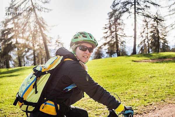 Mittlere erwachsene Frau auf dem Fahrrad  die in die Kamera schaut  Jenesien  Südtirol  Italien