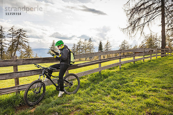 Frau auf Fahrrad Lesekarte  Jenesien  Südtirol  Italien