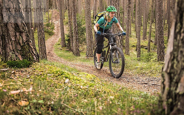 Mountainbike-Frau im Wald  Bozen  Südtirol  Italien
