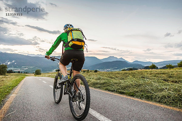 Frau radelt auf der Strasse  Fondo  Trentino  Italien