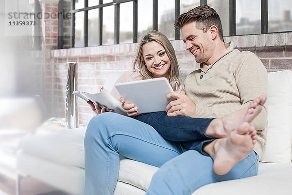 Paar zu Hause  entspannt auf dem Sofa  Blick auf das digitale Tablet