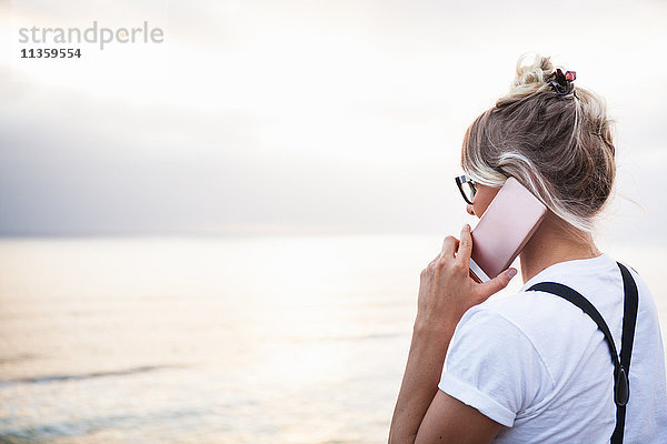 Frau am Meer telefoniert mit einem Smartphone  Encinitas  Kalifornien  USA