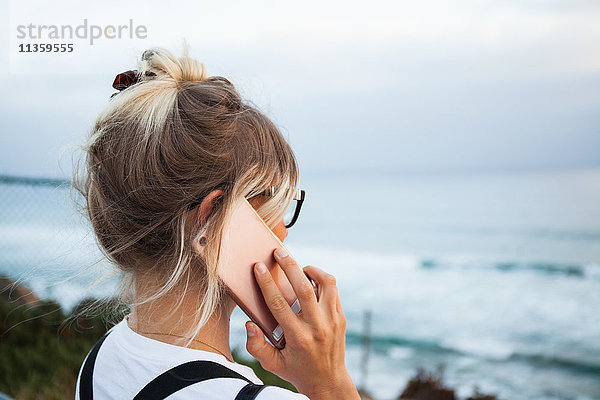 Frau am Meer telefoniert mit einem Smartphone  Encinitas  Kalifornien  USA