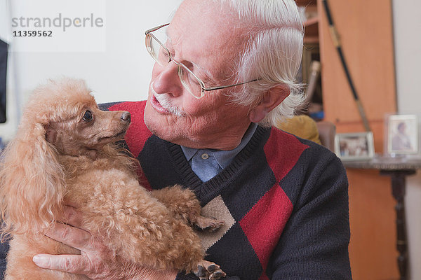 Senior Mann mit Haustier Hund zu Hause