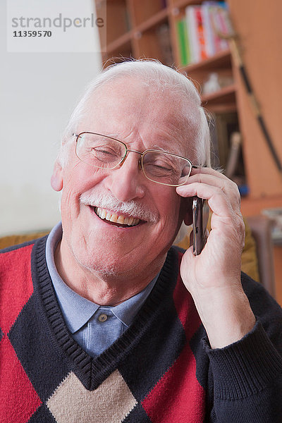 Senioren-Mann mit Handy zu Hause
