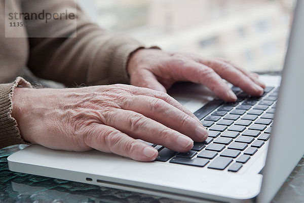 Älterer Mann benutzt Laptop zu Hause