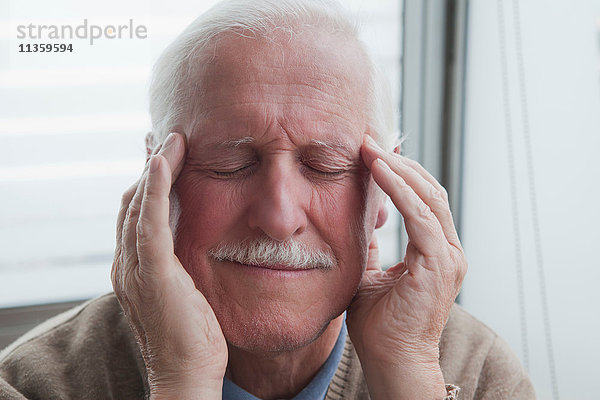 Älterer Mann leidet unter Kopfschmerzen