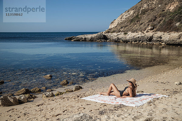 Junge Frau beim Sonnenbaden am Strand  Villasimius  Sardinien  Italien