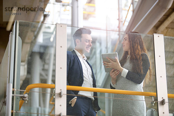 Geschäftsmann und Frau diskutieren über digitales Tablett auf der Stadttreppe  London  UK
