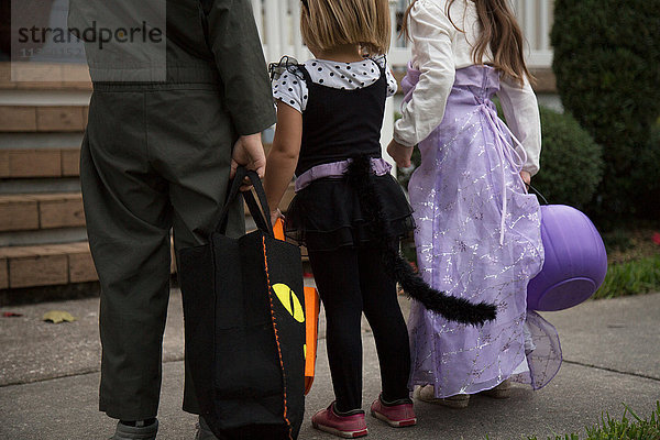 Junge und Schwestern betrügen oder behandeln das Warten auf der Verandatreppe.