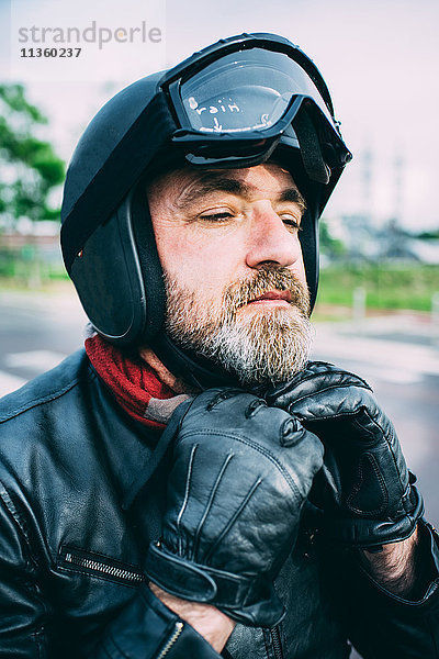 Älterer männlicher Motorradfahrer in schwarzer Lederjacke mit Verschluss