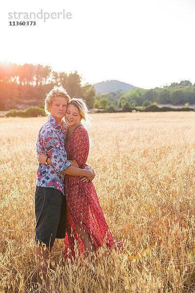 Porträt eines romantischen jungen Paares im Weizenfeld stehend  Mallorca  Spanien