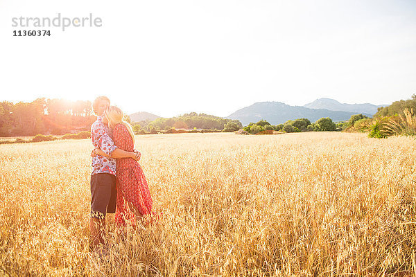 Romantisches junges Paar im Weizenfeld stehend  Mallorca  Spanien