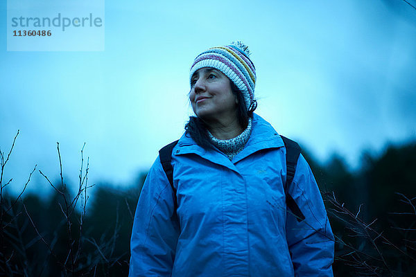 Wanderin wandert in der Dämmerung im Wald