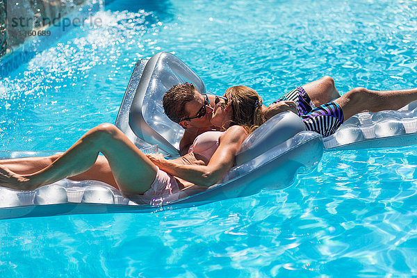Reifes Paar im Schwimmbad  Entspannung auf Hüpfburgen  Küssen