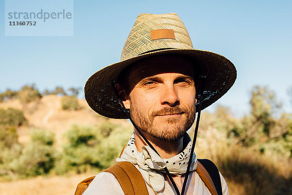 Porträt eines Mannes mit Sonnenhut  der lächelnd in die Kamera schaut  Malibu Canyon  Kalifornien  USA