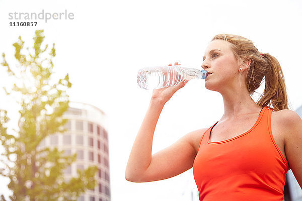 Frau trinkt aus Wasserflasche