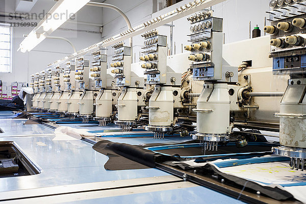 Reihen von programmierten Stickmaschinen beschleunigen das Sticken in einer Bekleidungsfabrik