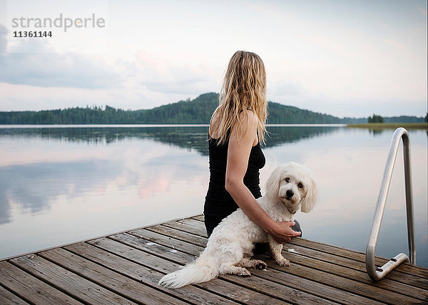 Frau mit coton de tulear Hund am Seepier  Orivesi  Finnland