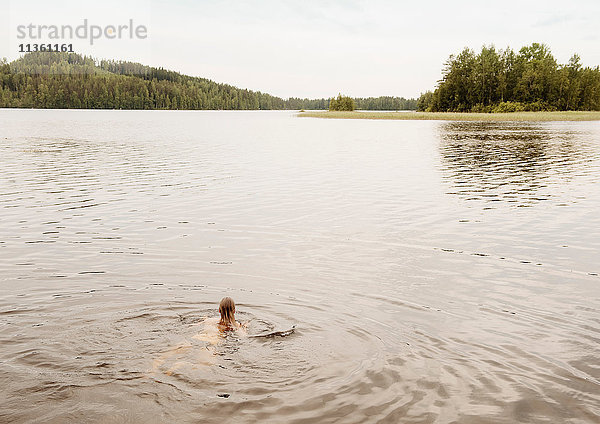 Frau schwimmt im See  Orivesi  Finnland