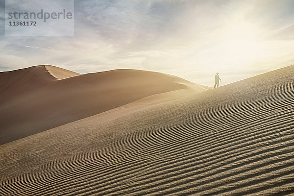 Silhouettierte Frau auf der Spitze einer Düne im Great Sand Dunes National Park  Colorado  USA