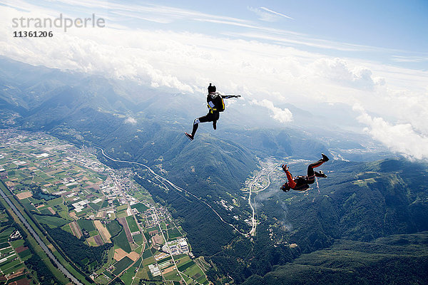 Freestyle Skydiving Team trainiert gemeinsam. Ein Mann führt Luftballett auf  ein anderer Springer filmt mit Videokamera am Helm  Locarno  Tessin  Schweiz