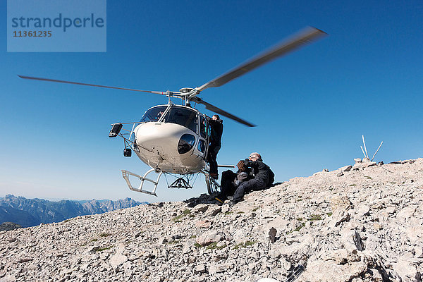 BASE-Sprungteam beim Verlassen des Hubschraubers auf dem Gipfel des Berges  Italienische Alpen  Alleghe  Belluno  Italien