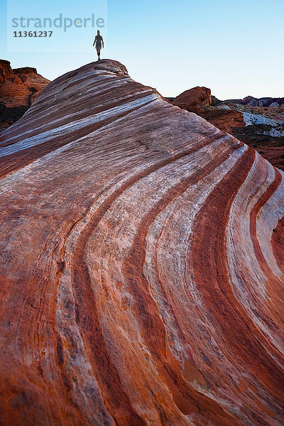 Silhouette einer Touristin bei der Erkundung von Sandsteinformationen im Valley of Fire State Park  Nevada  USA