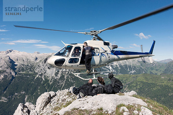 Männliches und weibliches BASE-Sprungteam beim Verlassen des Hubschraubers auf dem Gipfel des Berges Col di Pra  Italienische Alpen  Alleghe  Belluno  Italien