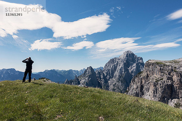 BASE-Jumper prüft den Wind und die Wolken  bevor er zum Klippenrand läuft  Italienische Alpen  Alleghe  Belluno  Italien