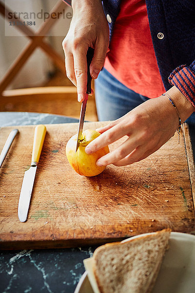 Ausschnitt einer Frau beim Apfelschneiden