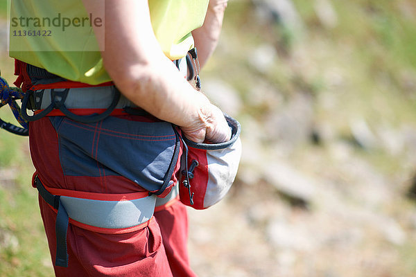 Schrägansicht eines Bergsteigers mit der Hand in der Tasche