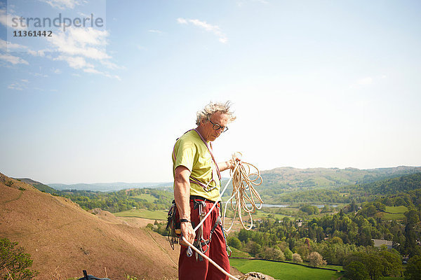 Bergsteiger am Hang bereitet Kletterseil vor