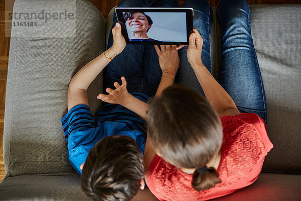 Draufsicht von Mutter und Sohn auf dem Sofa mittels digitalem Tablett