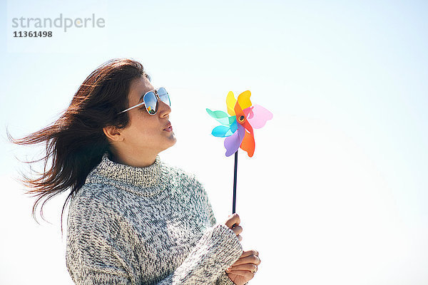 Frau mit Sonnenbrille hält Stiftrad