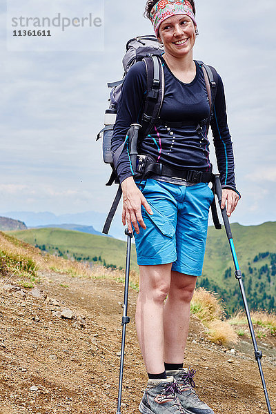 Wanderer mit Wanderstöcken schaut lächelnd weg  Österreich