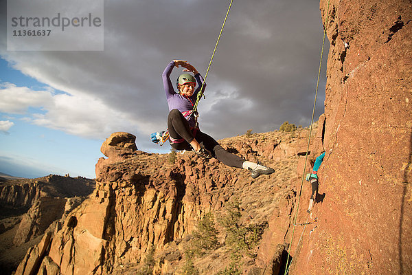 Felskletterin schwingt sich am Seil aus  Smith Rock State Park  Oregon  USA