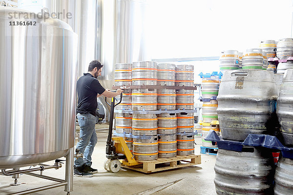 Arbeiter in einer Brauerei  der Bierfässer für die Auslieferung organisiert