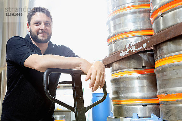 Porträt eines Arbeiters in einer Brauerei  der Bierfässer zur Auslieferung organisiert