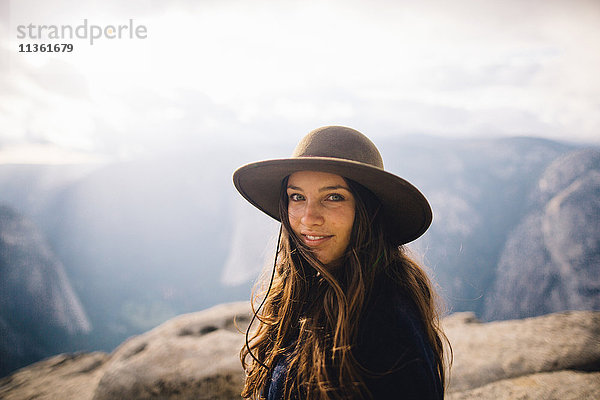 Porträt einer jungen Frau auf dem Gipfel eines Berges mit Blick auf den Yosemite-Nationalpark  Kalifornien  USA