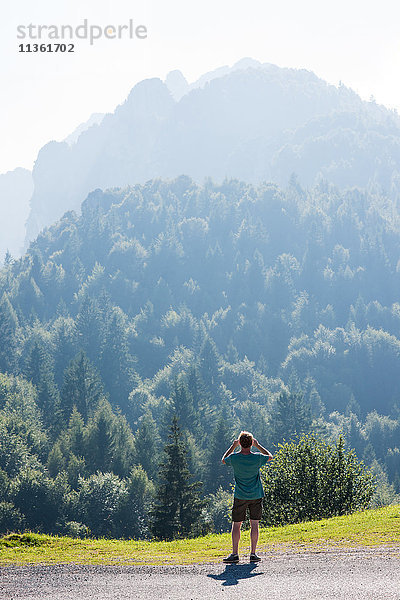 Rückansicht eines Menschen mit Blick auf die baumbestandenen Berge  Passo Maniva  Italien