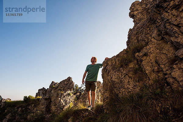 Auf Felsen stehender Mann schaut weg  Passo Maniva  Italien